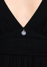 Black dress with a silver charm on a v neckline