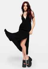 Woman wearing a floaty black dress on a white background