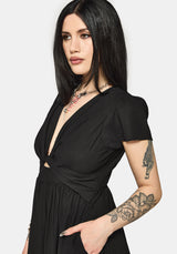 Woman wearing a black dress with cut-out design and short sleeves on a white background