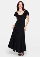 Woman wearing a black maxi dress with a high slit and ruffle sleeves on a white background