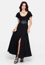 Woman wearing a black maxi dress with a high slit and ruffle sleeves on a white background