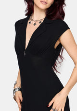Woman wearing a black dress with a plunging neckline on a white background