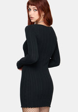Woman wearing a black ribbed mini dress against a white background