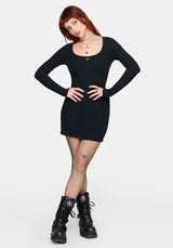 Woman wearing a black mini dress and black boots on a white background