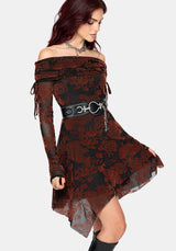 A woman modeling an off-the-shoulder gothic-style dress with a black and dark red floral lace overlay and sheer dark red lining, accessorized with a wide black belt featuring silver hardware.