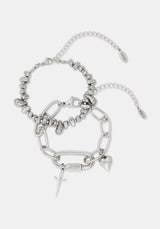 A stack of two silver-toned chain bracelets with charms, including a small sword, heart, and lock charms, displayed on a light gray background.