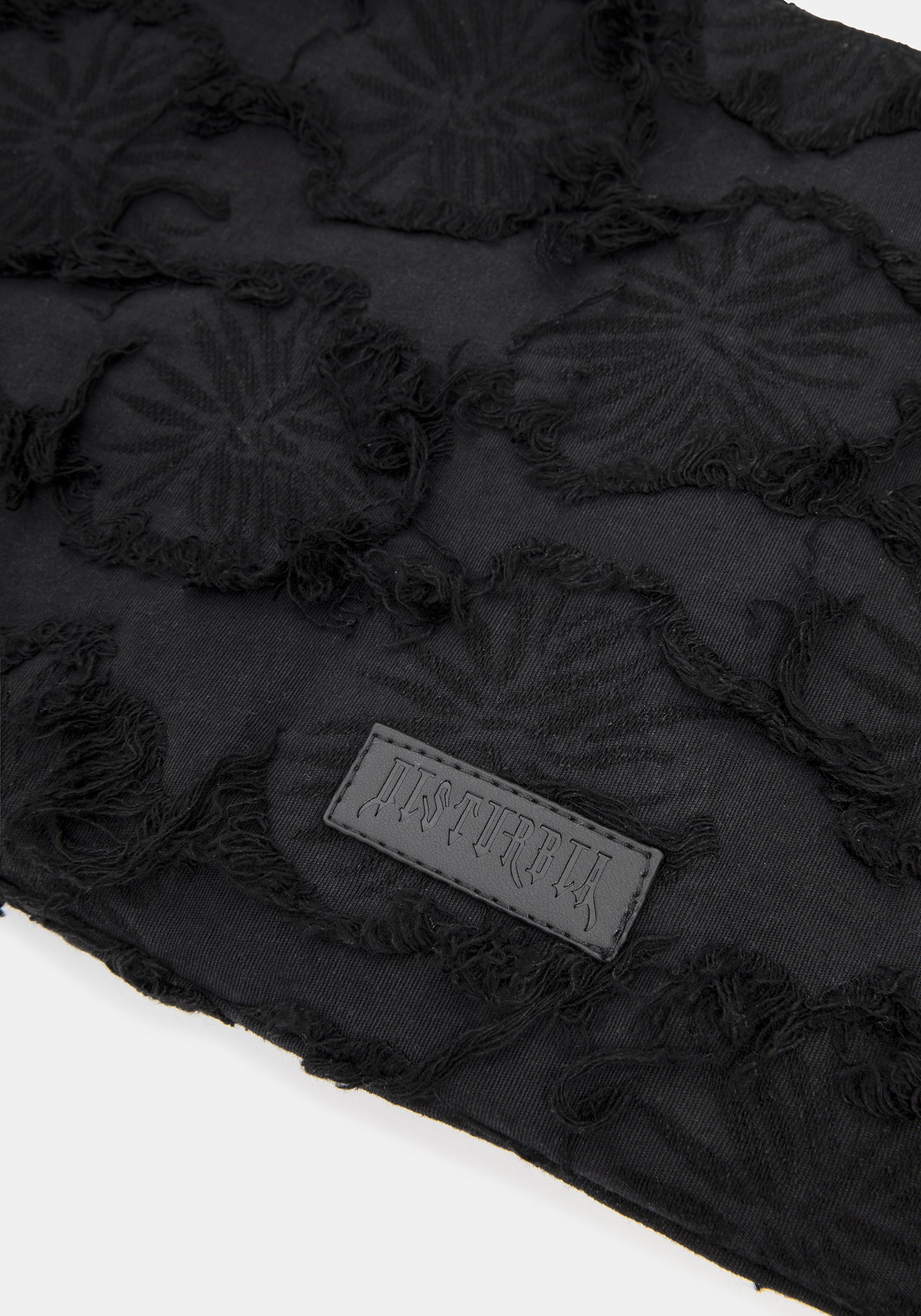 Close up of brand logo on a black textured shoulder bag