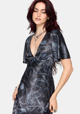 Woman wearing a black maxi satin snake printed dress on a white background