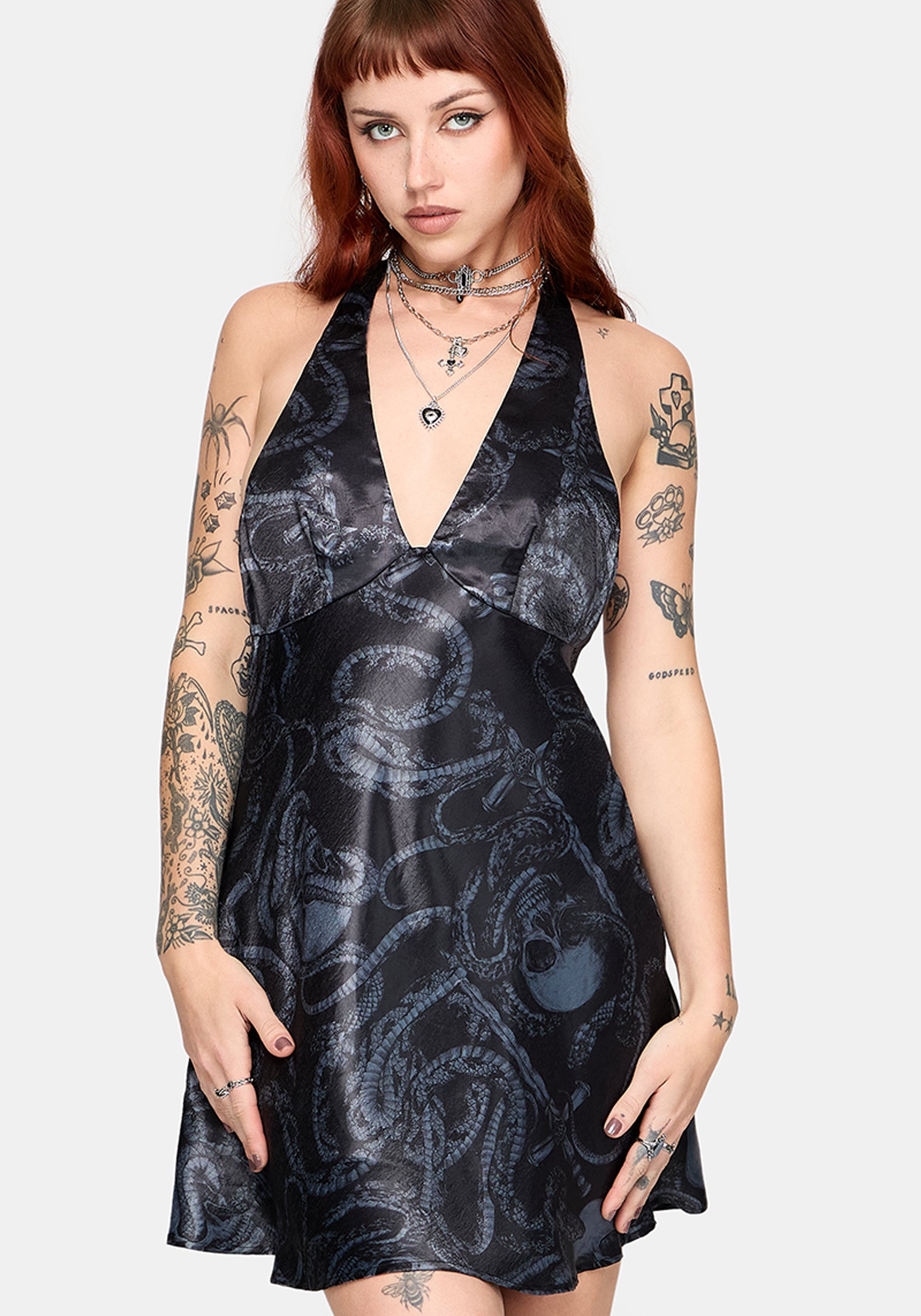 Woman wearing a black satin snake printed mini dress against a white background