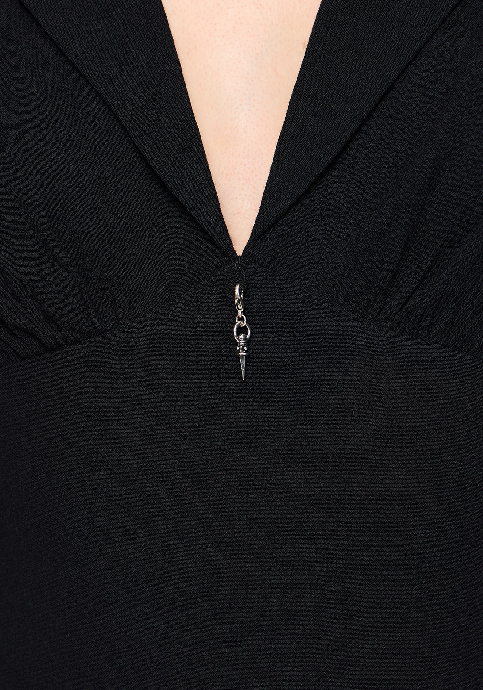Close-up of a black dress with a charm zipper detail.