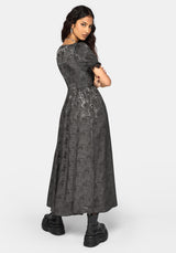 A woman modeling a dark gray short-sleeved midi dress with a textured, lace-like pattern, paired with black boots, against a light gray studio background.