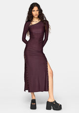 A woman modeling a long-sleeve, bodycon midi dress in deep plum purple with silver stud embellishments along the neckline, side seams, and hem, paired with black platform shoes against a light gray background.