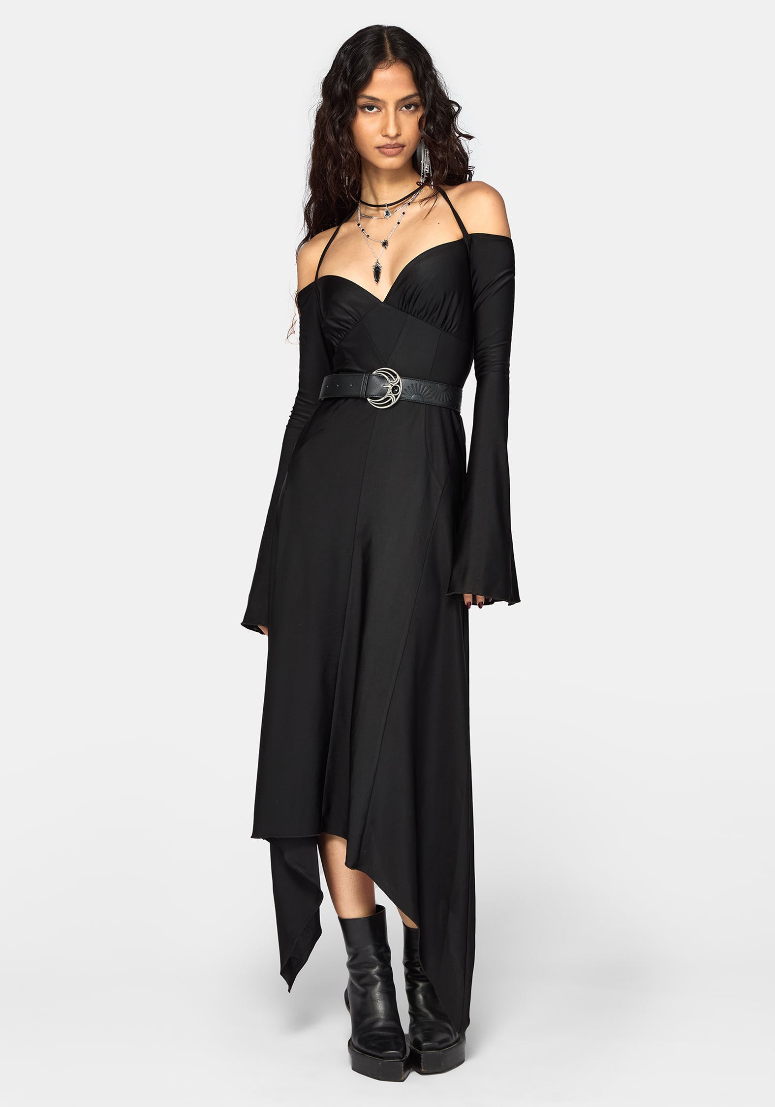 A model wearing a black off-the-shoulder midi dress with long bell sleeves, a sweetheart neckline, and a matching black belt with a silver buckle, styled with black platform ankle boots against a light gray background.