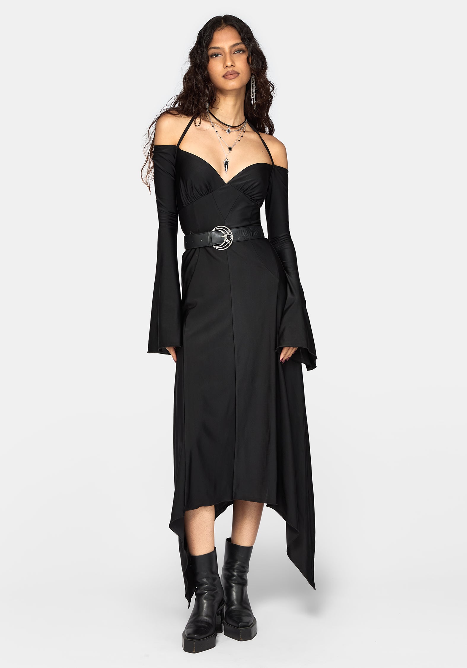 A model wearing a black off-the-shoulder midi dress with long bell sleeves, a sweetheart neckline, a matching black belt with a silver buckle, and black platform ankle boots, set against a plain light gray background.