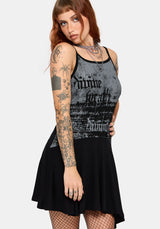 A woman modeling a sleeveless black and gray graphic mini dress, shown against a plain light gray studio background.