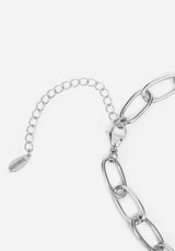 Silver chain link bracelet featuring a chunky oval link chain, a delicate extender chain, and a small engraved tag that reads 'DISTURBIA'.