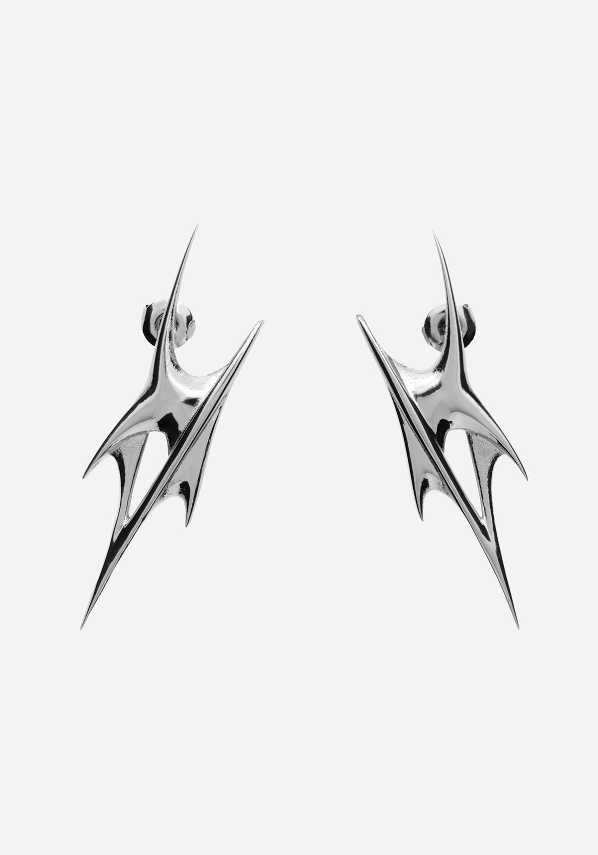 A pair of silver-toned geometric drop earrings with a sharp, angular spike design, shown against a plain light gray background.