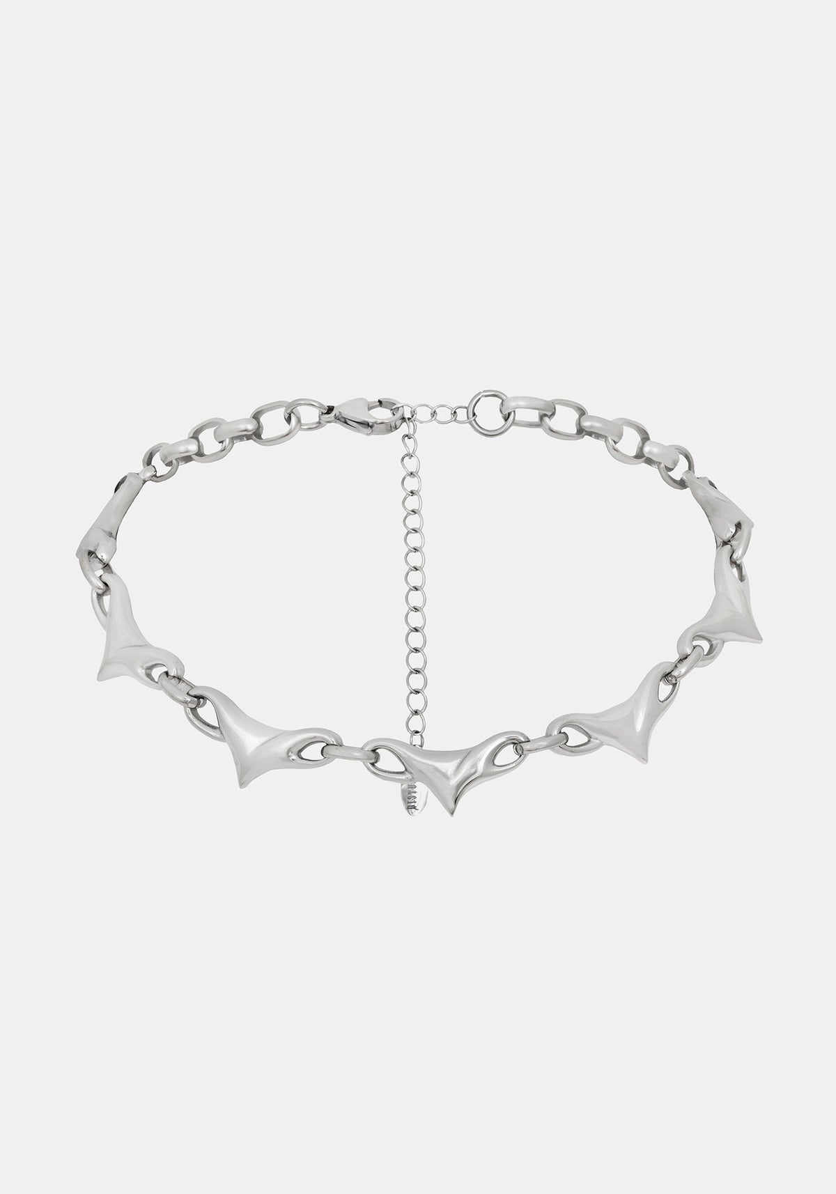 A silver-toned chain necklace featuring elongated, pointed spike links and a central extender chain, shown against a light gray background.