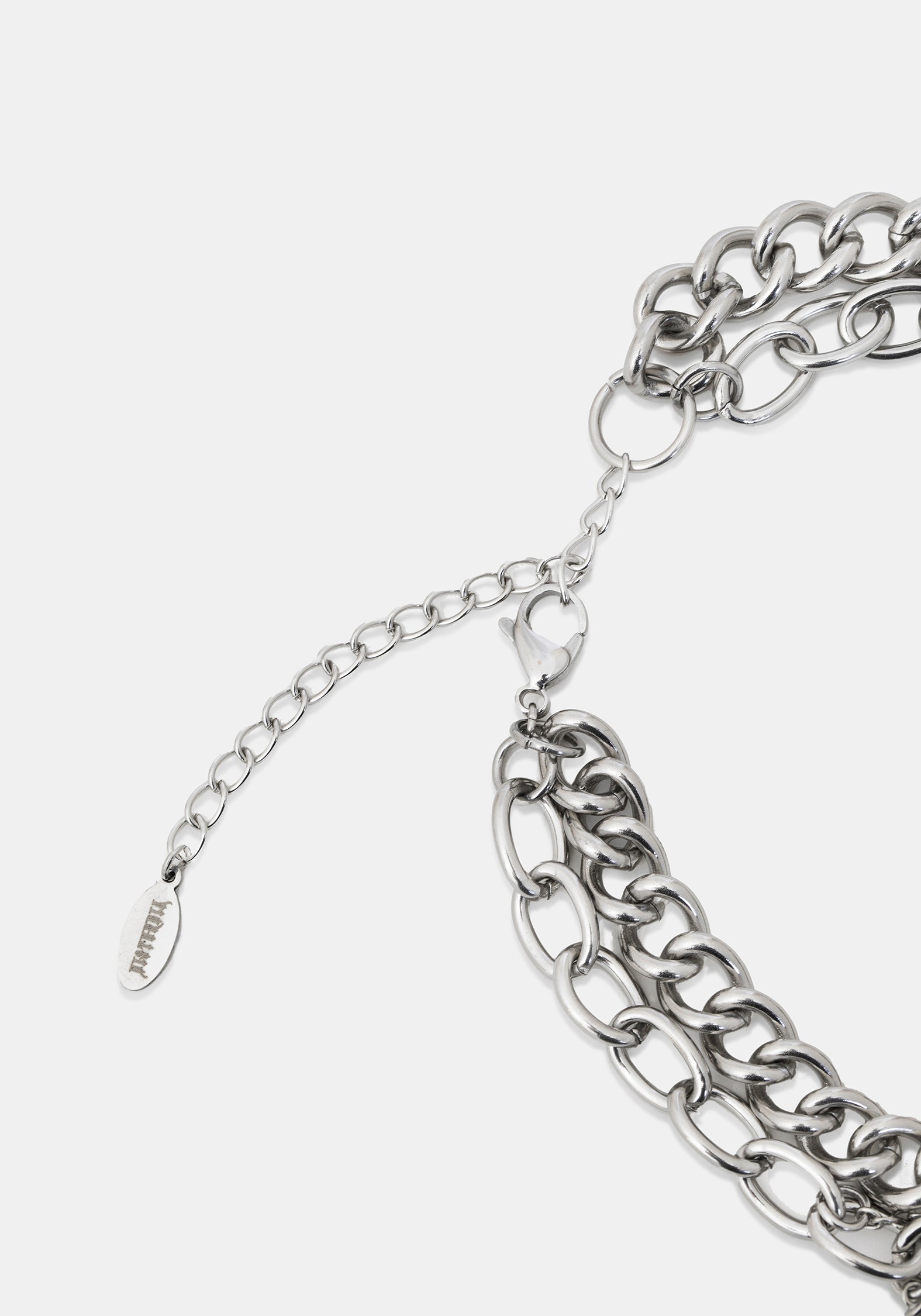 Close-up of a silver-toned chunky chain necklace with an adjustable extender chain and a small branded tag, photographed on a light gray background.
