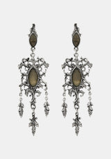 A pair of ornate silver-toned filigree dangle earrings with oval brown stone accents, shown against a light gray background.
