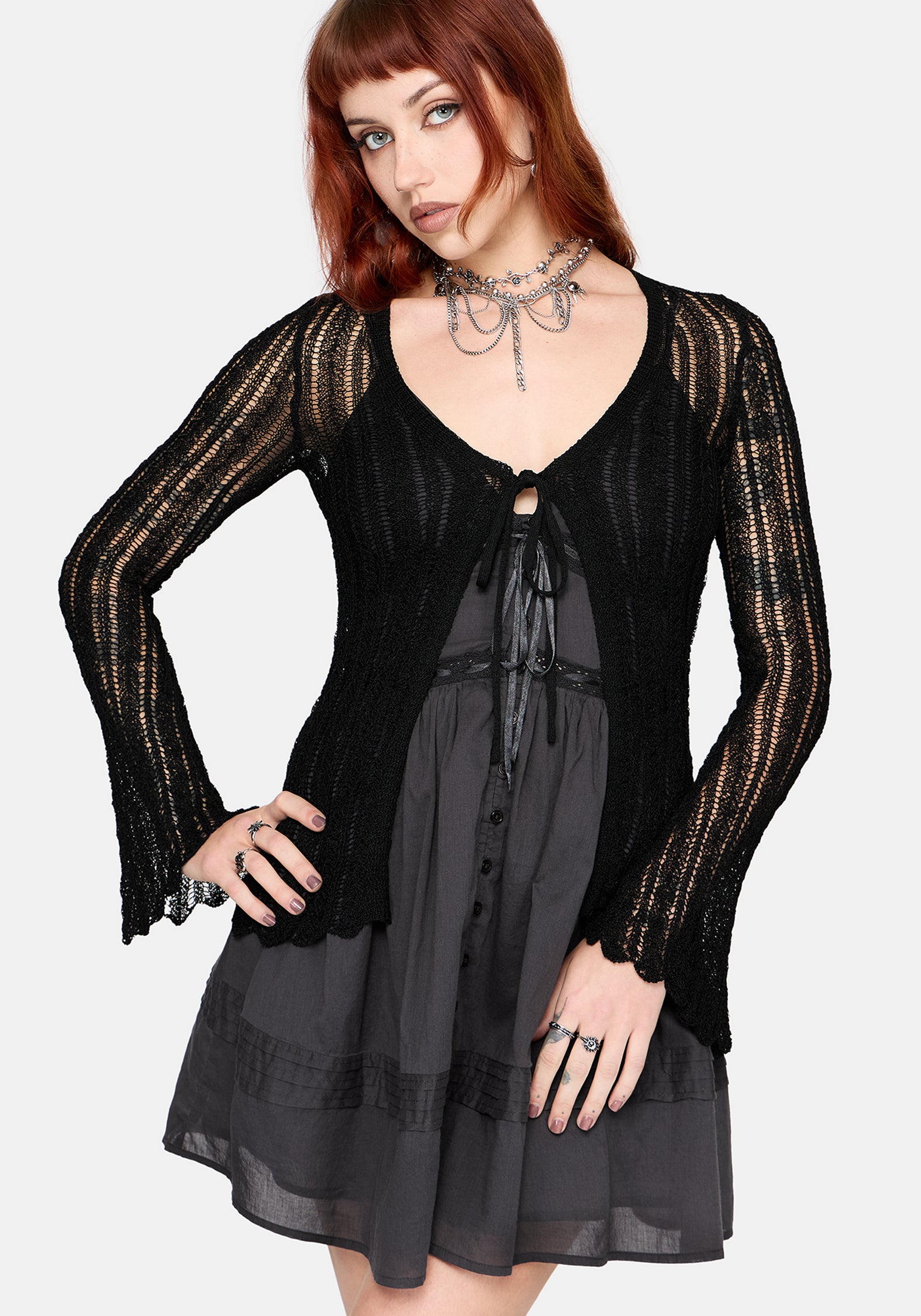 Women's black long sleeve distressed cardigan with v-neckline and self tie function at chest, against a white studio background