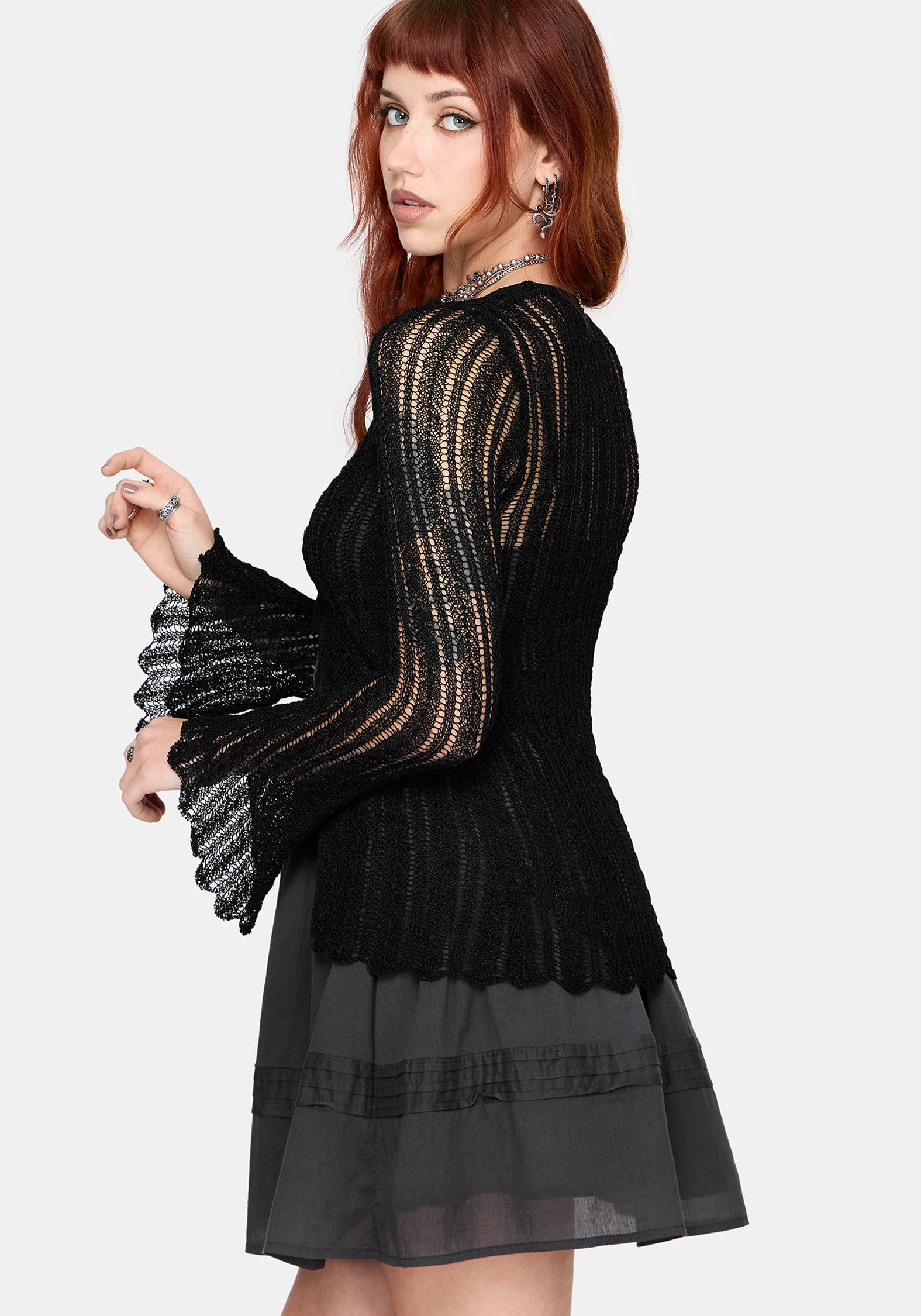 Women's black long sleeve distressed cardigan with v-neckline and self tie function at chest, against a white studio background