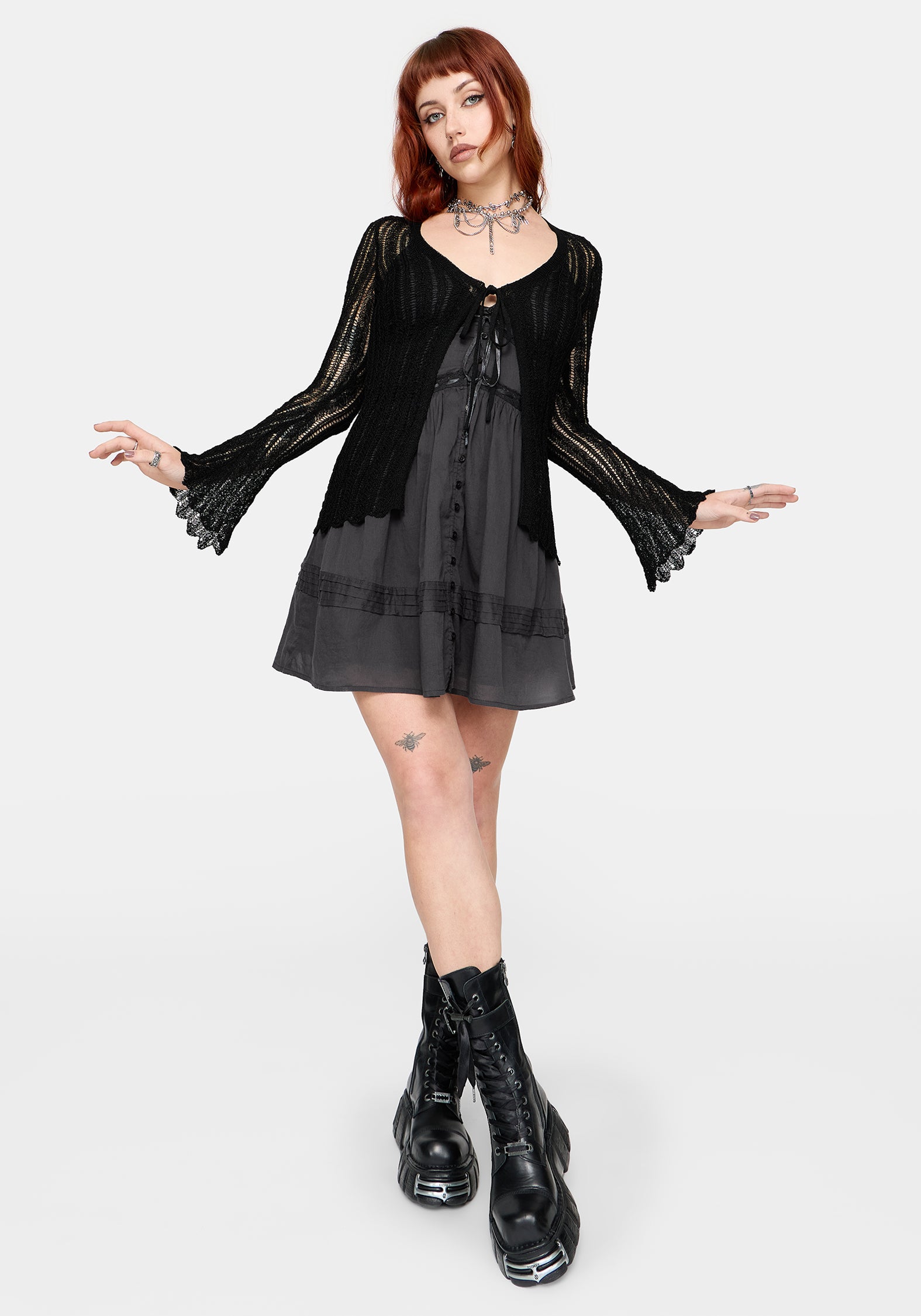 Women's black long sleeve distressed cardigan with v-neckline and self tie function at chest, against a white studio background