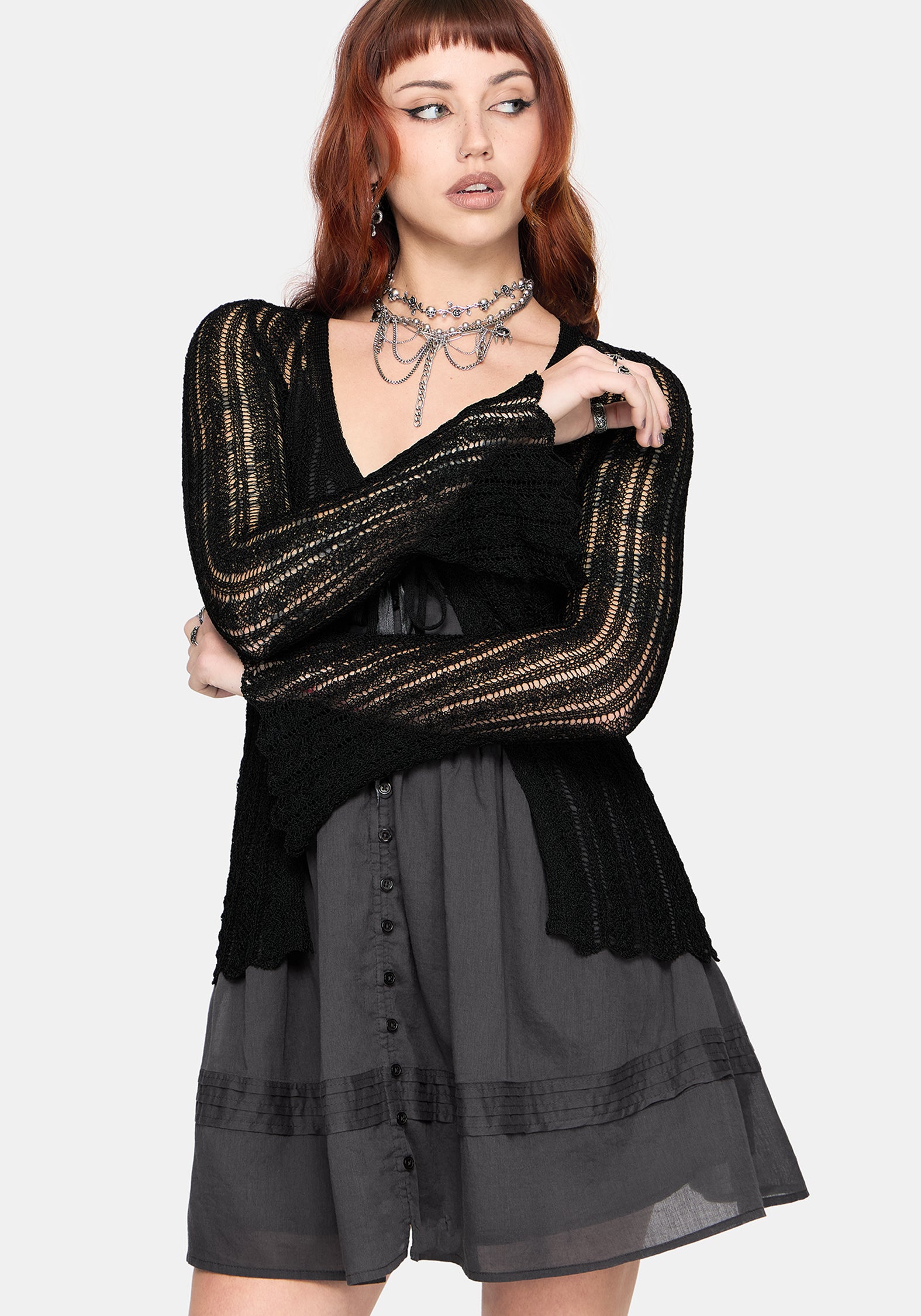 Women's black long sleeve distressed cardigan with v-neckline and self tie function at chest, against a white studio background