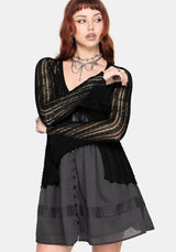 Women's black long sleeve distressed cardigan with v-neckline and self tie function at chest, against a white studio background