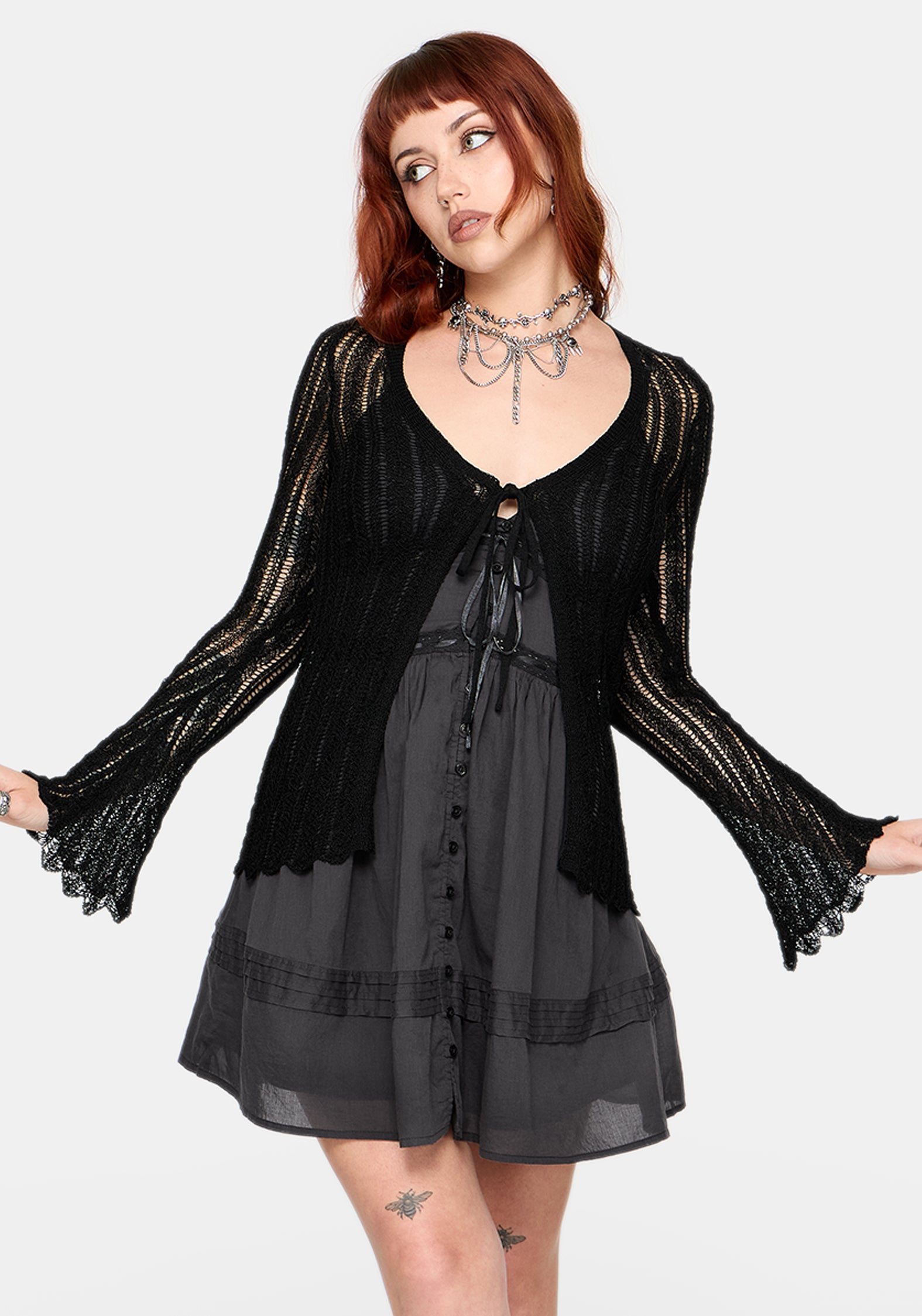 Women's black long sleeve distressed cardigan with v-neckline and self tie function at chest, against a white studio background