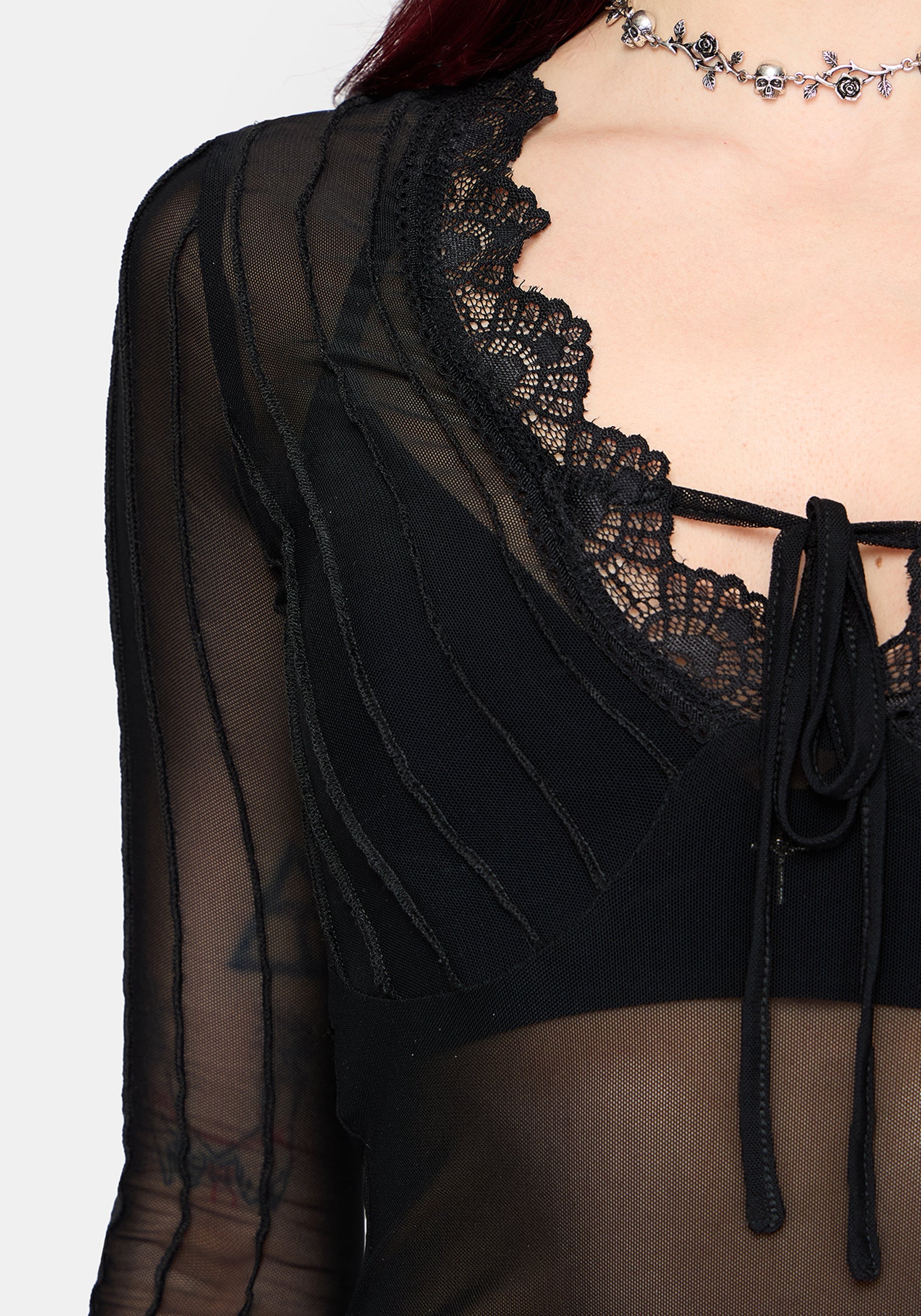 Black lace detail top with sheer sleeves on a white background