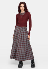 A model wearing a dark red ribbed long-sleeve button-up cardigan and a high-waisted, pleated plaid maxi skirt in red, gray, and black, styled with layered silver necklaces and black platform boots against a light gray background.