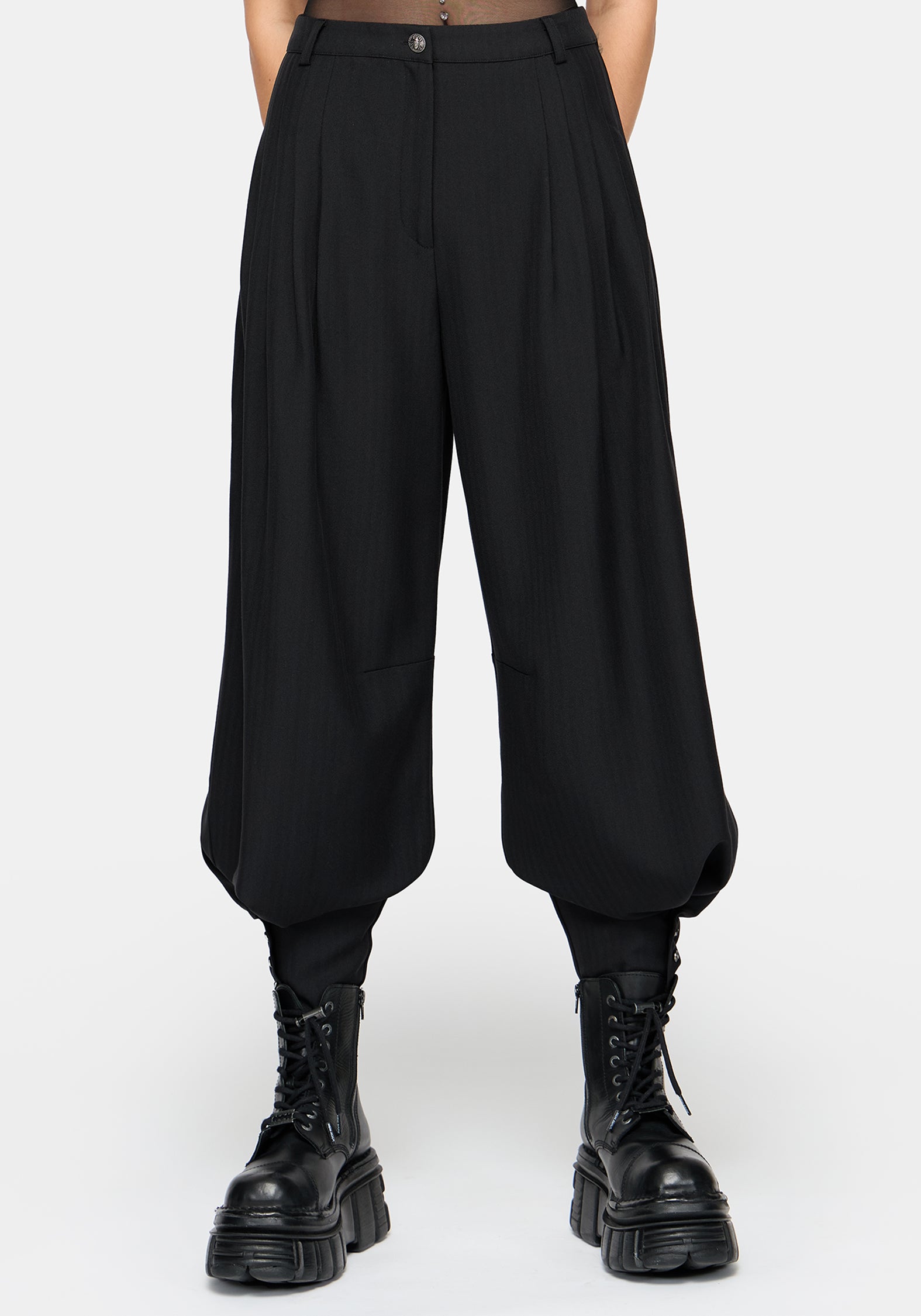 A model wearing a black sheer mesh short-sleeve crop top and matching black balloon pants with cuffs, styled with chunky black platform boots against a light gray background.